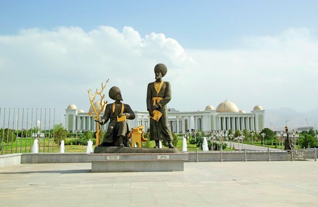 Turkmenistan: Skulpturen nationaler Schriftsteller in der Hauptstadt Aşgabat, im Hintergrund die Nationalbibliothek. Das Land hat eine immerwährende Neutralität proklamiert und sich von der Außenwelt großteils abgeschottet